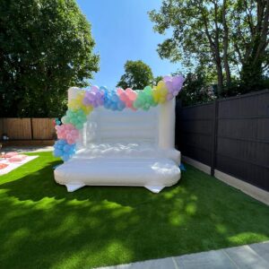white bouncy castle with balloon garland